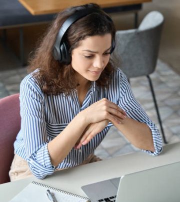 Hispanic girl college student wearing headphones watching distance online learning web class, remote university webinar or having talk on laptop video call virtual meeting seminar at home or campus.